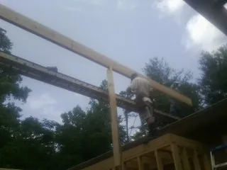 Carpenter setting a ridge beam over a new addition frame — Ice Dam Removal by Roofing Brothers in Fairdale
