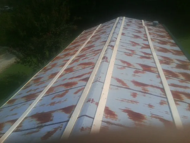 Rusted metal roof panels with new wood purlins before replacement — Storm Damage Roof Repair in Fairdale by Roofing Brothers
