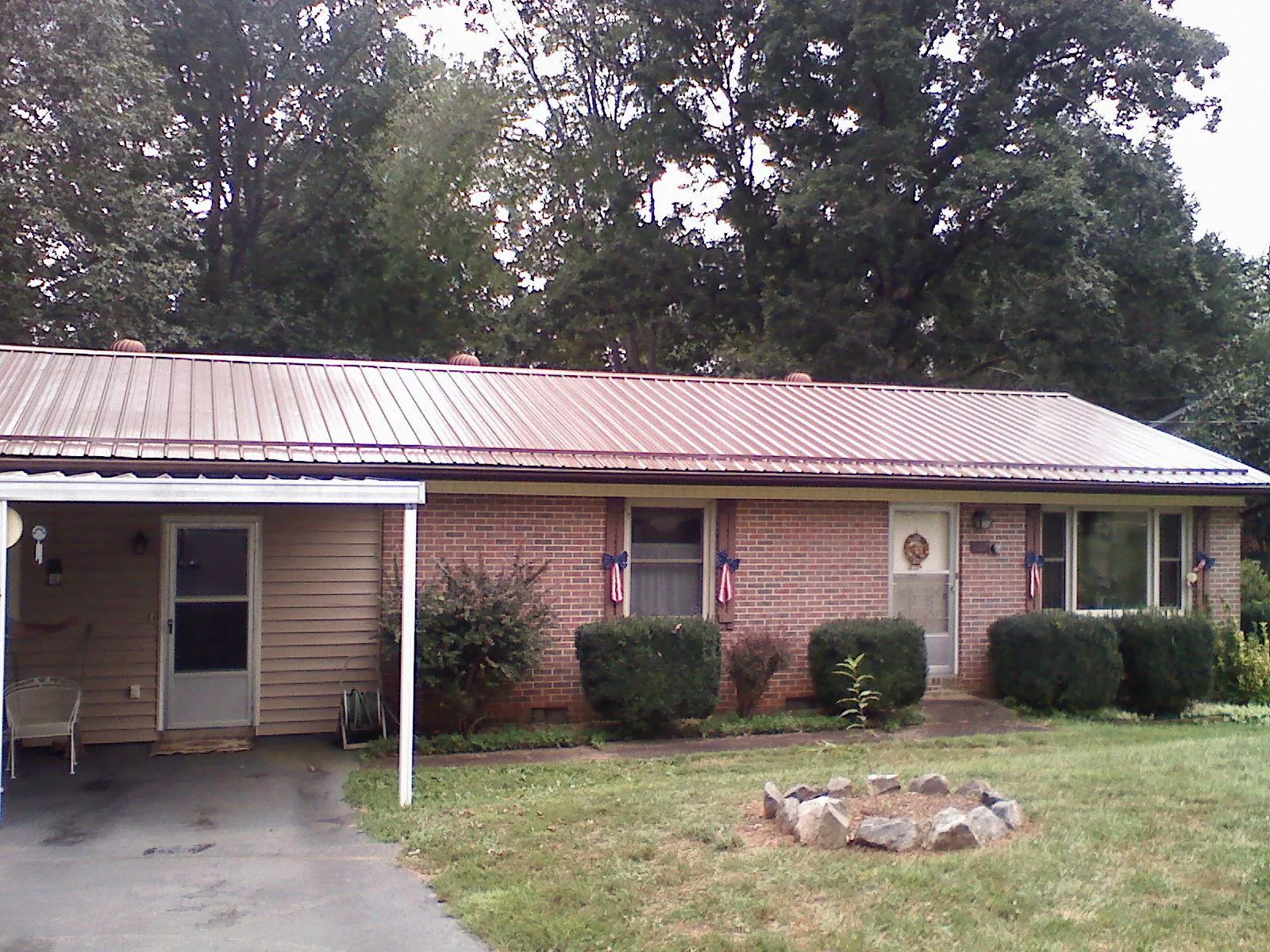 Bronze metal roof and carport on a brick ranch home — Roof Repair work by our crew in Fairdale